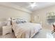 Bright bedroom with ceiling fan, tile floors, and coordinated white bedroom furniture at 5134 Northridge Rd # 106, Sarasota, FL 34238
