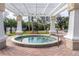 Community hot tub featuring a covered pergola, brick pavers, and access handrail at 5134 Northridge Rd # 106, Sarasota, FL 34238