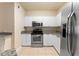 Bright kitchen featuring stainless steel appliances, white cabinets, and tile flooring at 5134 Northridge Rd # 106, Sarasota, FL 34238