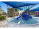 Fun playground area with colorful equipment under a shady canopy, perfect for children to enjoy a sunny day outdoors at 5134 Northridge Rd # 106, Sarasota, FL 34238