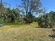 Large grassy lot with mature trees and clear blue skies at 534 Lewis St, Englewood, FL 34223