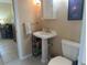 Cozy bathroom featuring a pedestal sink, toilet, and storage rack at 534 Lewis St, Englewood, FL 34223