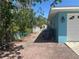 View of the side of the house with a brick driveway and foliage at 534 Lewis St, Englewood, FL 34223