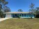 Charming blue single-story home featuring a well-maintained lawn, inviting facade, and pristine white trim at 534 Lewis St, Englewood, FL 34223