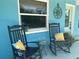Inviting front porch with rocking chairs, a small table, and colorful pillows, perfect for relaxing at 534 Lewis St, Englewood, FL 34223