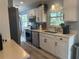 Bright kitchen featuring white cabinets, stainless steel appliances, and a view to the breakfast nook at 534 Lewis St, Englewood, FL 34223
