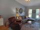 Comfortable living room featuring a sectional sofa, leather recliner, and a clear coffee table at 534 Lewis St, Englewood, FL 34223