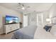 The bright bedroom has great natural light, a mounted flatscreen TV, and ensuite bathroom and closet entrances at 5520 Coachwood Cv, Bradenton, FL 34211