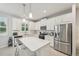 This spacious kitchen features an island, white cabinetry, and stainless steel appliances at 5520 Coachwood Cv, Bradenton, FL 34211