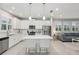 Bright kitchen features stainless appliances, white cabinets, central island with bar seating, and easy access to the living area at 5520 Coachwood Cv, Bradenton, FL 34211