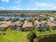 Stunning aerial view of luxury homes on a lake with beautiful landscaping and a golf course in the background at 5637 Arnie Loop, Bradenton, FL 34211