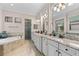 Beautiful bathroom with tile floors, double sinks, granite counters, soaking tub and walk-in shower at 5637 Arnie Loop, Bradenton, FL 34211