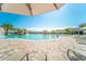 Beautiful community pool area with cascading waterfall, lounge chairs, and palm trees under a clear blue sky at 5637 Arnie Loop, Bradenton, FL 34211