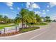 Elegant gated community entrance with lush landscaping, vibrant flowers, and palm trees under a sunny sky at 5637 Arnie Loop, Bradenton, FL 34211