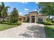 Lovely single-story home featuring manicured landscaping, a brick driveway, and an arched entryway at 5637 Arnie Loop, Bradenton, FL 34211