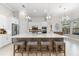 Open kitchen with a large island, bar stools, stainless appliances, and stylish pendant lighting at 5637 Arnie Loop, Bradenton, FL 34211