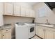 Well-equipped laundry room with modern washer and dryer, sink, granite countertop, and plenty of storage at 5637 Arnie Loop, Bradenton, FL 34211