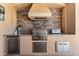 Outdoor kitchen features stainless steel grill, stone backsplash, granite countertops, and built in storage at 5637 Arnie Loop, Bradenton, FL 34211