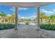 Scenic patio view showcasing manicured landscaping, palm trees, and a luxurious community pool in the background at 5637 Arnie Loop, Bradenton, FL 34211