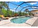 The screened-in pool and spa are surrounded by tropical landscaping, providing a private oasis for relaxation at 5637 Arnie Loop, Bradenton, FL 34211
