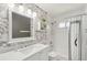 Bright bathroom features a vanity with marble countertop and decorative floral wallpaper at 5728 Whistlewood Cir, Sarasota, FL 34232