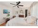 Comfortable bedroom with ceiling fan, hardwood floors, and ample natural light at 5728 Whistlewood Cir, Sarasota, FL 34232