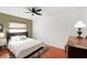 Well-lit bedroom featuring hardwood floors and a stylish headboard at 5728 Whistlewood Cir, Sarasota, FL 34232