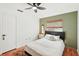 Bright bedroom features hardwood floors, ceiling fan, and a modern headboard at 5728 Whistlewood Cir, Sarasota, FL 34232