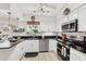 Bright kitchen features stainless appliances, dark countertops, and white cabinets at 5728 Whistlewood Cir, Sarasota, FL 34232