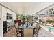 Covered patio with outdoor dining set and view of the pool and landscaped backyard at 5728 Whistlewood Cir, Sarasota, FL 34232
