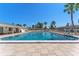 Beautiful pool on a sunny day with lounge chairs, palm trees, and a clean fence at 6087 Coral Way, Bradenton, FL 34207