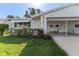 A cozy single-story home with a carport, awning-covered window, and lush greenery in the front yard provides an inviting curb appeal at 6087 Coral Way, Bradenton, FL 34207