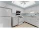 Well-lit kitchen featuring white cabinetry, appliances, and a tiled floor at 6087 Coral Way, Bradenton, FL 34207