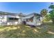 An exterior view of the home with awning-shaded windows and a well-maintained lawn at 6087 Coral Way, Bradenton, FL 34207