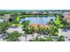 Aerial view showing beautiful landscaping, a pond with a fountain, and well-maintained community buildings at 6228 Champions Row St, Bradenton, FL 34210