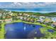 Scenic aerial view showcasing waterfront homes, lush landscaping, and a serene lake with fountain at 6228 Champions Row St, Bradenton, FL 34210