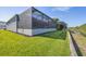 A beautiful backyard with a screened-in lanai, green lawn, and a canal view at 6228 Champions Row St, Bradenton, FL 34210