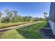 A green backyard lawn slopes to a canal lined with lush greenery at 6228 Champions Row St, Bradenton, FL 34210
