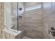 Walk-in shower with a glass door, gray tile, and chrome fixtures at 6228 Champions Row St, Bradenton, FL 34210