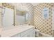 Stylish bathroom featuring a quartz countertop vanity and decorative wallpaper at 6228 Champions Row St, Bradenton, FL 34210