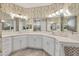 Luxurious primary bathroom featuring double sinks, vanity, sleek white cabinets, quartz countertops, and decorative lighting at 6228 Champions Row St, Bradenton, FL 34210