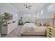 Comfortable bedroom with soft blue walls, ceiling fan, shutters, and an ensuite bathroom at 6228 Champions Row St, Bradenton, FL 34210