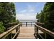 Wooden dock overlooking a serene body of water, surrounded by lush greenery and clear blue skies at 6228 Champions Row St, Bradenton, FL 34210