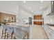 Open kitchen with white cabinets, quartz countertops, and contrasting wood cabinetry in the distance at 6228 Champions Row St, Bradenton, FL 34210