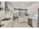 Open concept kitchen boasts white cabinets, stainless appliances, ample counter space, and adjacent breakfast bar at 6228 Champions Row St, Bradenton, FL 34210