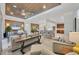 Open-concept living room flows into the kitchen, featuring stylish seating, and a wood plank ceiling at 6228 Champions Row St, Bradenton, FL 34210