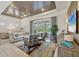 Bright living room boasts a decorative ceiling, comfortable seating, and sliding doors to the patio at 6228 Champions Row St, Bradenton, FL 34210