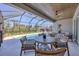 Screened patio with outdoor dining and lounging area overlooking pool at 6228 Champions Row St, Bradenton, FL 34210