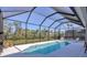 Sparkling pool with screened enclosure, surrounded by lush landscaping at 6228 Champions Row St, Bradenton, FL 34210