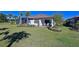 Well-maintained backyard with green grass, palm trees, patio, and an inviting outdoor seating area at 6308 Plateau Ct, Bradenton, FL 34203